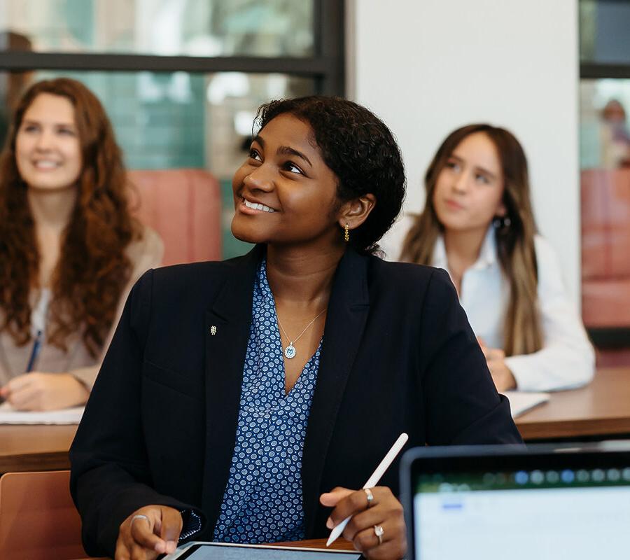 female students smiling and taking notes at 推荐全球最大网赌正规平台欢迎您